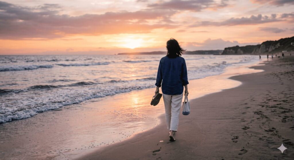 夕暮れの海岸を一人でゆったりと歩く大人の後ろ姿